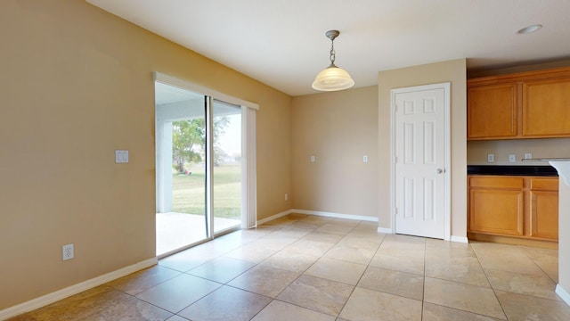 unfurnished dining area with baseboards and light tile patterned floors