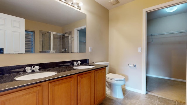 bathroom featuring vanity, toilet, an enclosed shower, and tile patterned flooring