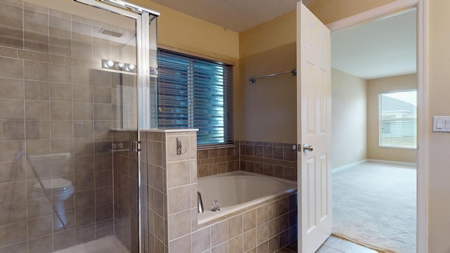 full bathroom featuring a stall shower, baseboards, toilet, tile patterned floors, and a bath