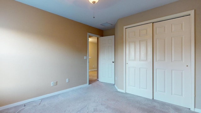 unfurnished bedroom with a closet and light carpet