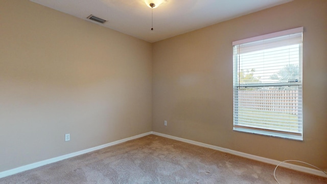 unfurnished room featuring visible vents, light carpet, and baseboards