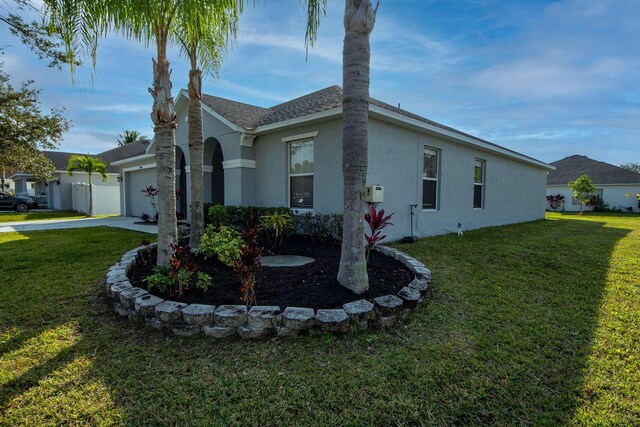 single story home with a garage and a front lawn