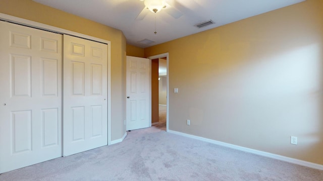 unfurnished bedroom with light colored carpet, a ceiling fan, baseboards, visible vents, and a closet