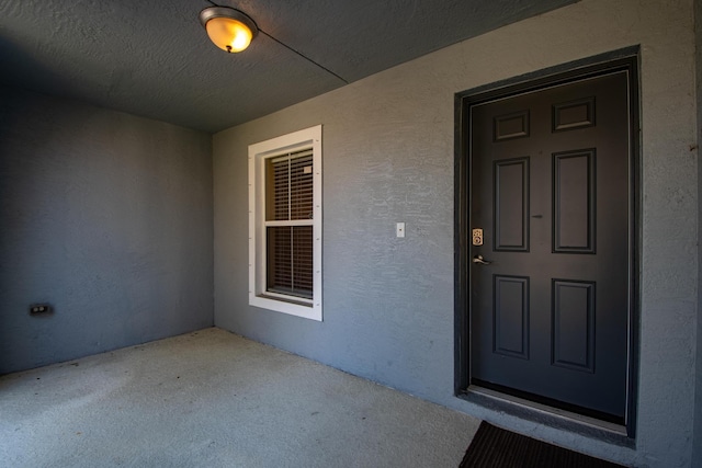 view of exterior entry with stucco siding