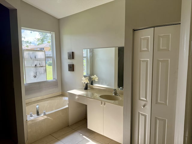 bathroom featuring vanity, lofted ceiling, a bath, and tile patterned floors