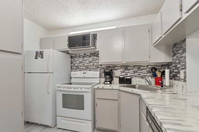 kitchen with sink, a textured ceiling, backsplash, and white appliances