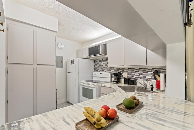 kitchen with sink, white appliances, white cabinetry, backsplash, and a textured ceiling