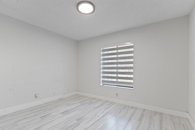 unfurnished room with light hardwood / wood-style floors and a textured ceiling