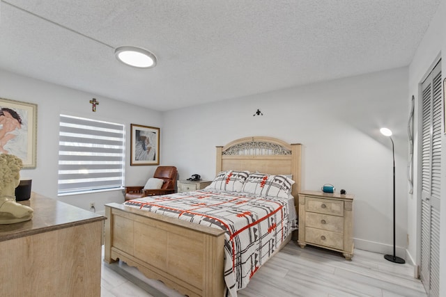 bedroom with light hardwood / wood-style floors, a closet, and a textured ceiling