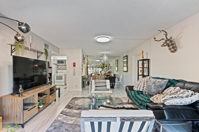 living room with light hardwood / wood-style floors and a textured ceiling