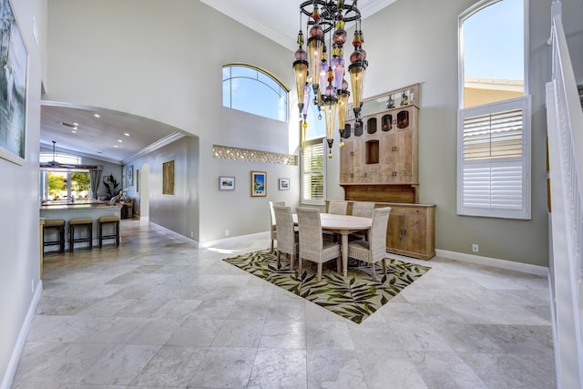 dining space with crown molding, plenty of natural light, and a high ceiling