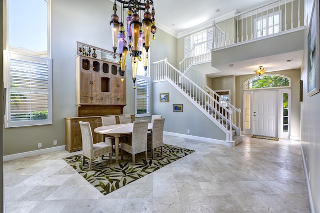 dining room featuring an inviting chandelier, ornamental molding, and a high ceiling