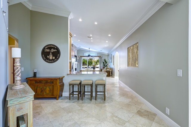 kitchen with vaulted ceiling, a breakfast bar, crown molding, kitchen peninsula, and stainless steel refrigerator with ice dispenser