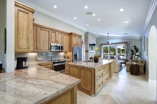 kitchen featuring sink, light stone counters, stainless steel appliances, a kitchen island with sink, and decorative backsplash