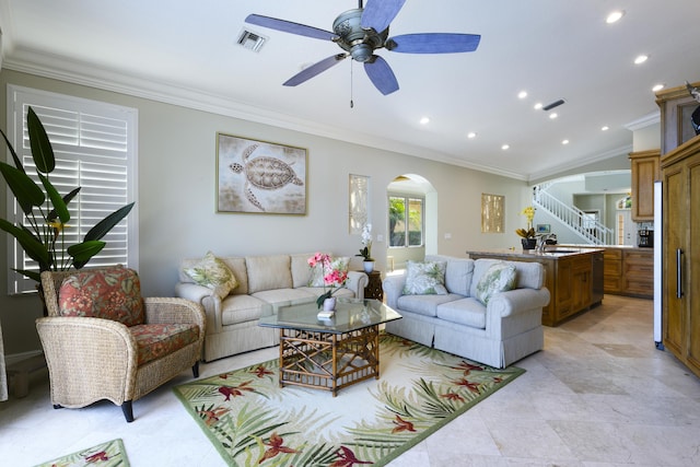 living room with crown molding, sink, and ceiling fan