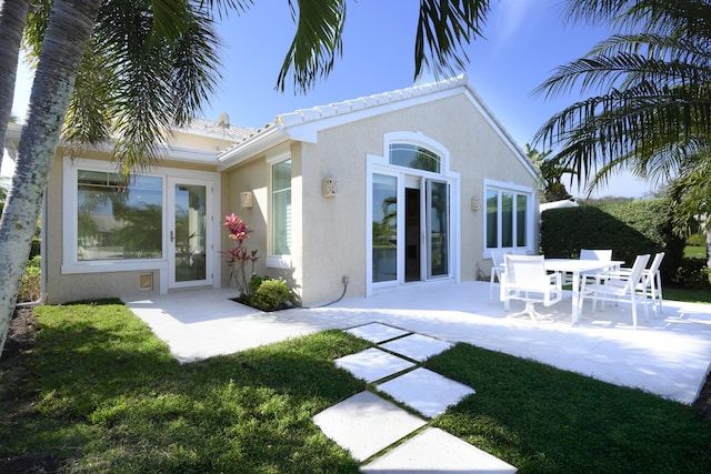 back of house with a yard and a patio area