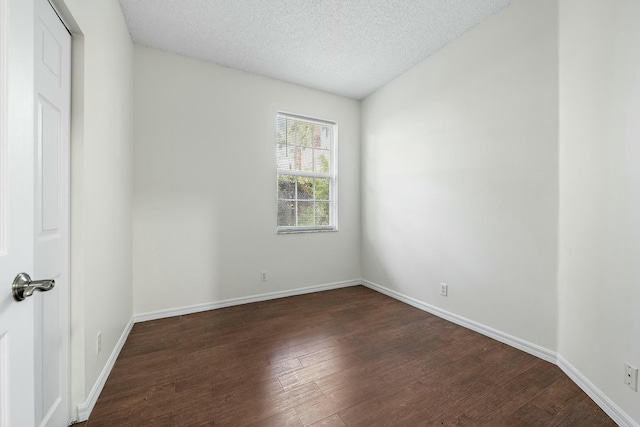 unfurnished room featuring dark wood-type flooring and a textured ceiling