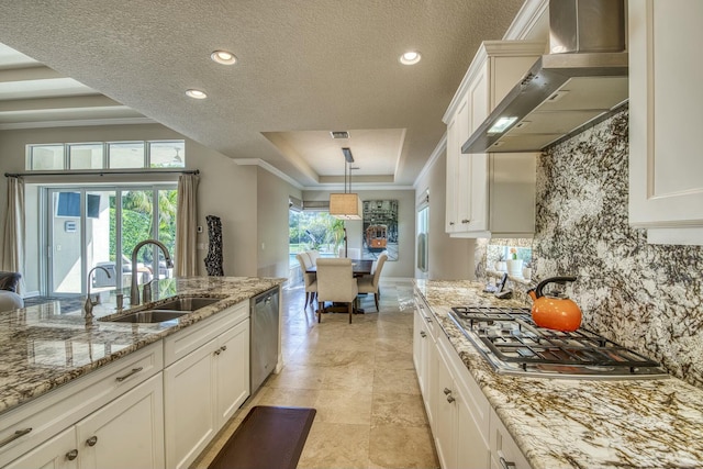 kitchen featuring wall chimney range hood, stainless steel appliances, sink, and white cabinets