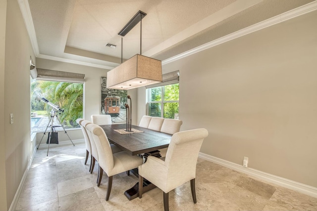 dining room featuring a tray ceiling, a wealth of natural light, ornamental molding, and a textured ceiling