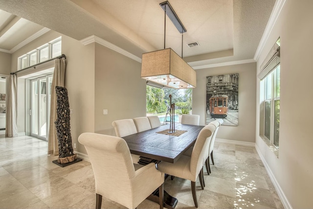 dining area featuring a raised ceiling, crown molding, and a textured ceiling