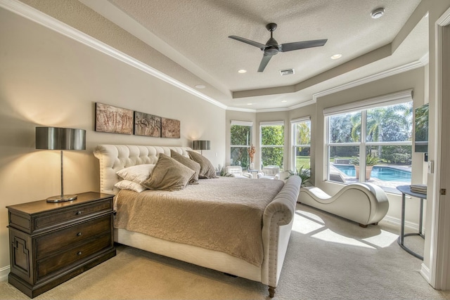 carpeted bedroom with a raised ceiling, ornamental molding, a textured ceiling, and multiple windows