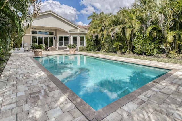 view of swimming pool with grilling area and a patio area