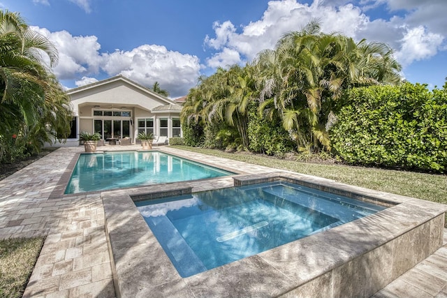 view of swimming pool featuring a patio area and an in ground hot tub