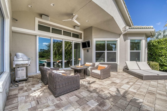 view of patio featuring area for grilling, an outdoor living space with a fire pit, and ceiling fan