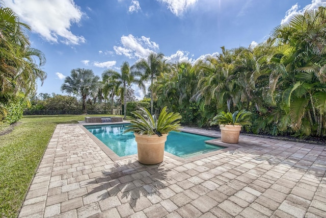 view of pool with a yard, a jacuzzi, and a patio