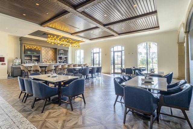 dining space featuring parquet flooring, coffered ceiling, and beam ceiling