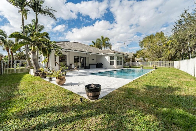 view of swimming pool with a yard, a fenced in pool, a patio, and a fenced backyard