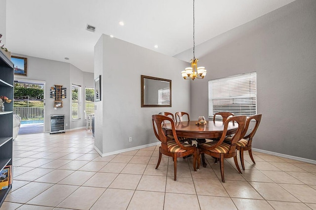 dining room featuring light tile patterned flooring, vaulted ceiling, beverage cooler, and an inviting chandelier