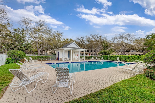 community pool featuring fence and a patio area