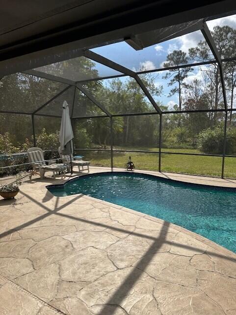 view of pool featuring a patio area and glass enclosure