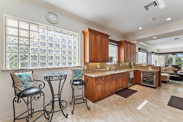 kitchen with tasteful backsplash, stainless steel dishwasher, a kitchen bar, and kitchen peninsula