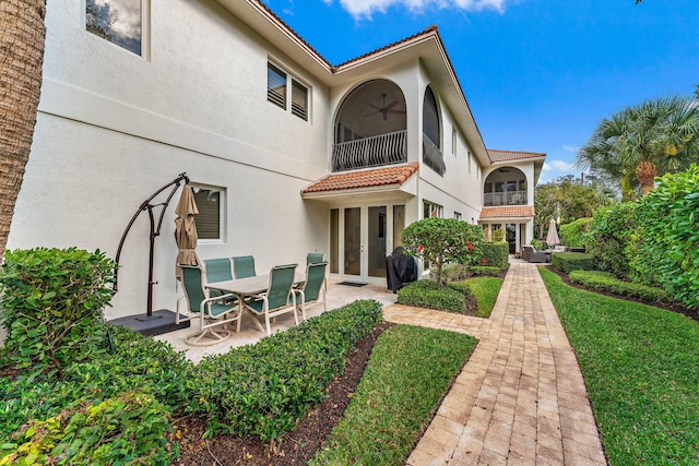 back of house featuring a patio, a balcony, ceiling fan, and french doors