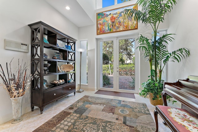 foyer with french doors, a wall mounted AC, and a high ceiling