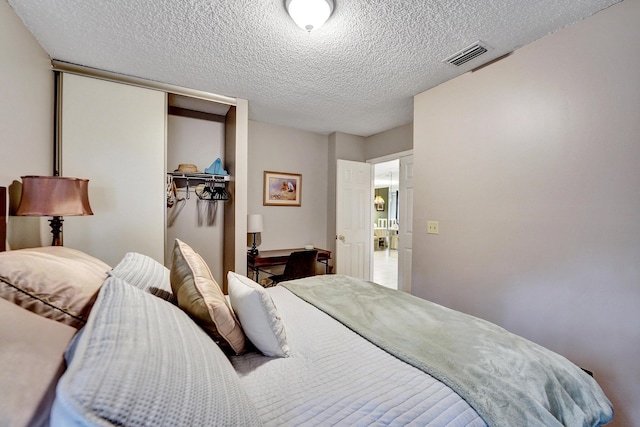 bedroom featuring a textured ceiling and a closet