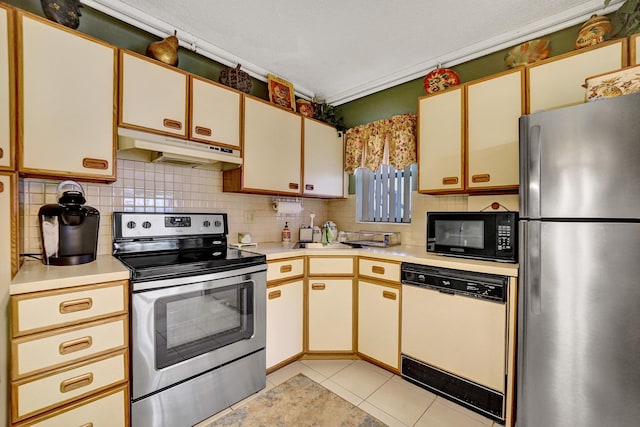 kitchen with light tile patterned floors, sink, appliances with stainless steel finishes, tasteful backsplash, and white cabinets