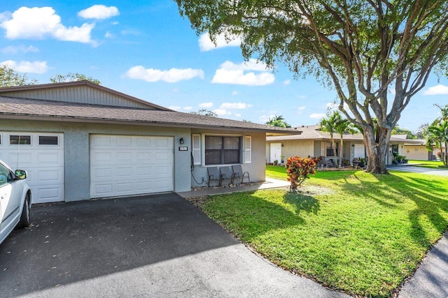 ranch-style house with aphalt driveway, a front yard, an attached garage, and stucco siding