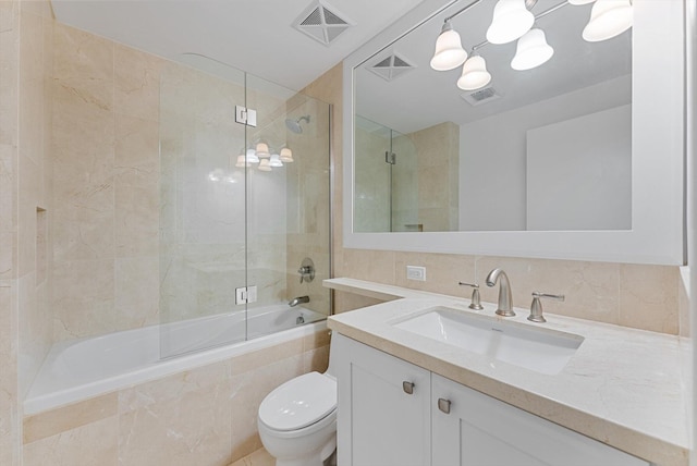 full bathroom with vanity, backsplash, enclosed tub / shower combo, and toilet