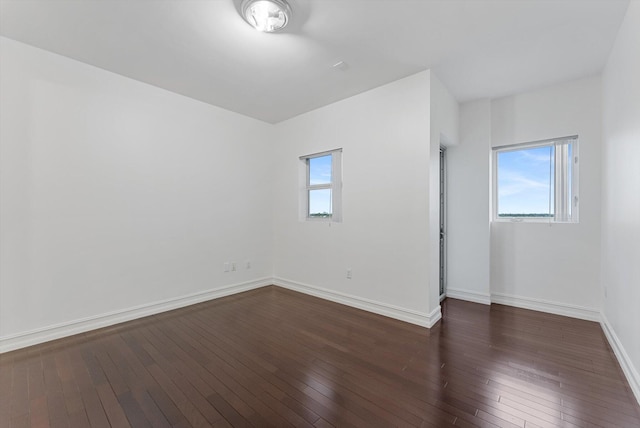 unfurnished room with dark wood-type flooring and a wealth of natural light