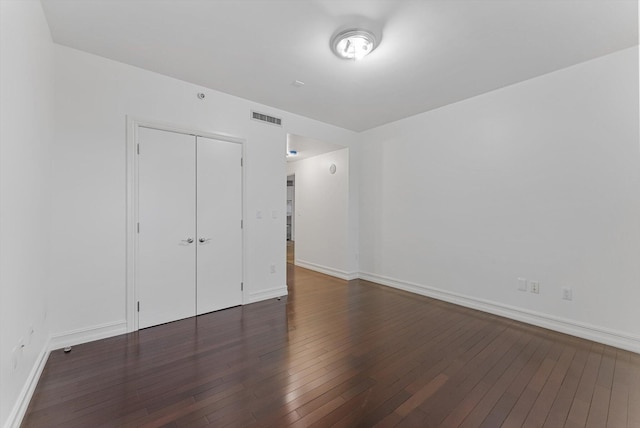 unfurnished bedroom featuring dark hardwood / wood-style flooring and a closet