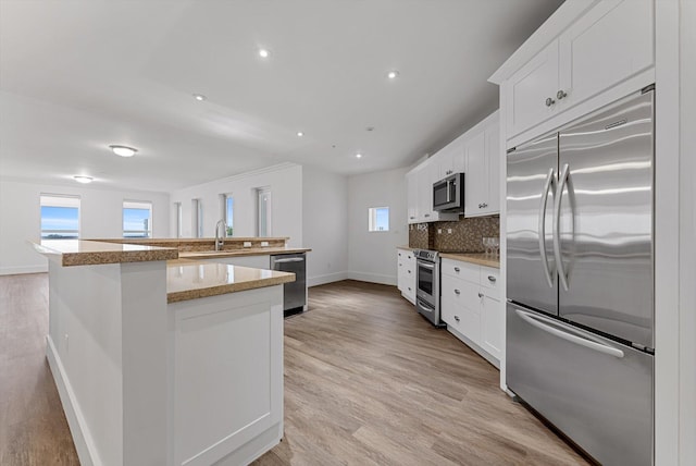 kitchen with white cabinetry, a wealth of natural light, and stainless steel appliances