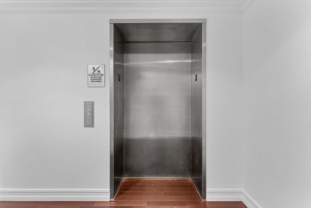 interior space with ornamental molding and dark hardwood / wood-style floors