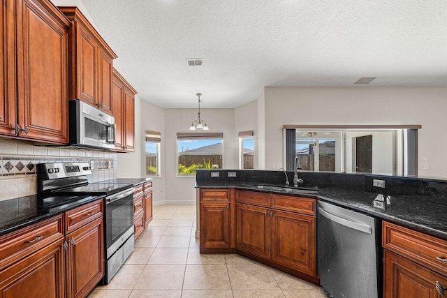 kitchen featuring tasteful backsplash, visible vents, appliances with stainless steel finishes, a sink, and light tile patterned flooring