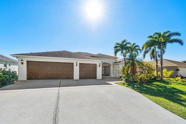 view of front of property with an attached garage, a front lawn, concrete driveway, and stucco siding