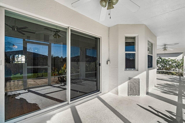 exterior space featuring ceiling fan and stucco siding