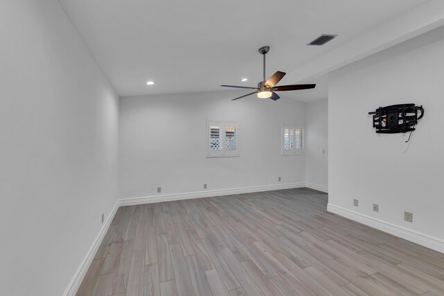 empty room featuring ceiling fan, vaulted ceiling, and light hardwood / wood-style flooring