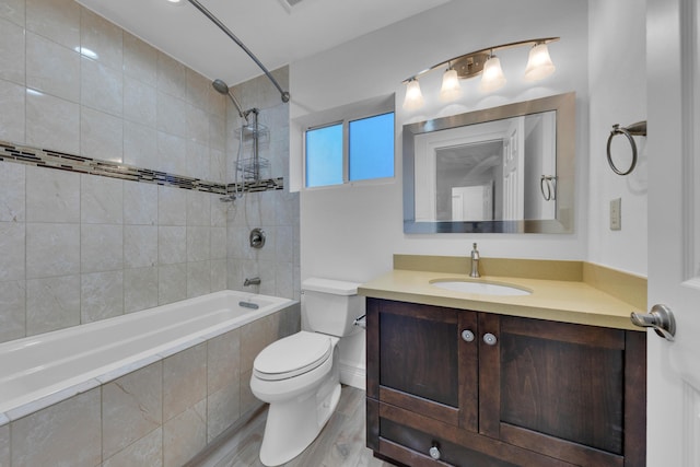 full bathroom with vanity, hardwood / wood-style floors, tiled shower / bath combo, and toilet